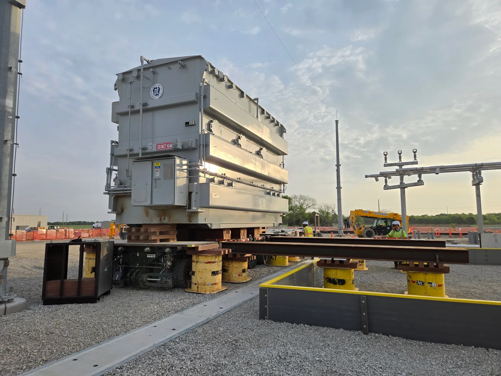 Power transformer on cribbing and steel slide rails during a jack and slide move