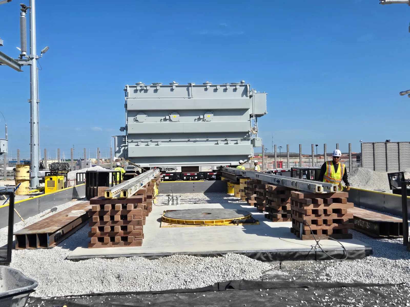 Heavy transformer positioned on slide rails and cribbing during a jack and slide installation